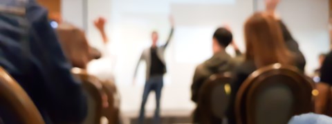 blurred group of people meeting in motivation seminar event at convention hall, speaker raising hand up and audience action follow , cheerful conceptblurred group of people meeting in motivation seminar event at convention hall, speaker raising hand up and audience action follow , cheerful concept